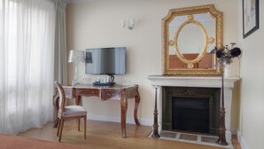 A room with a wooden desk, a television, a fireplace, and a large mirror. - Hôtel Le 123 Elysées - Astotel (Paris)