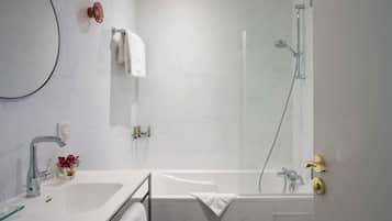 Une salle de bain moderne équipée d’une baignoire, d’une douche, d’un lavabo et d’un miroir.