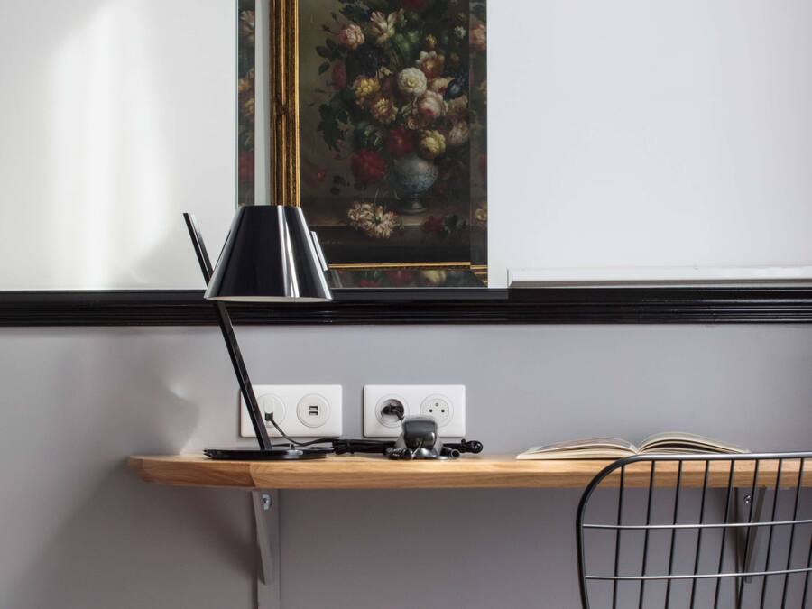 Een bureau met een lamp, een stopcontact en een open boek.