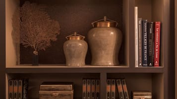 Una estantería con jarrones decorativos, libros y una obra de arte enmarcada.