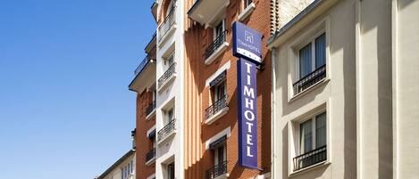 Een meerlaags hotelgebouw met een opvallend 'TimHotel Paris' bord.