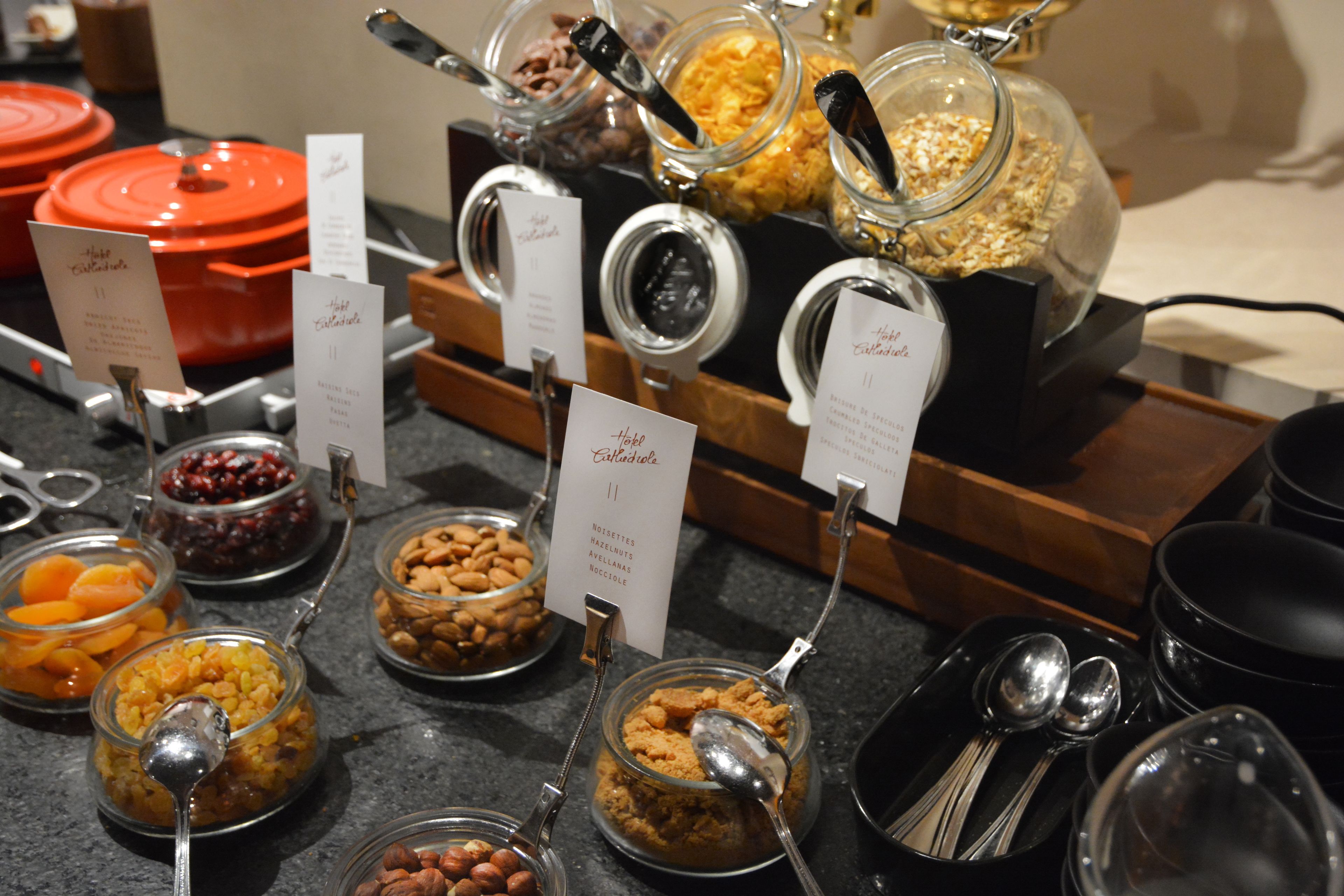 A buffet with various food items in glass containers, each labeled with a name and number.