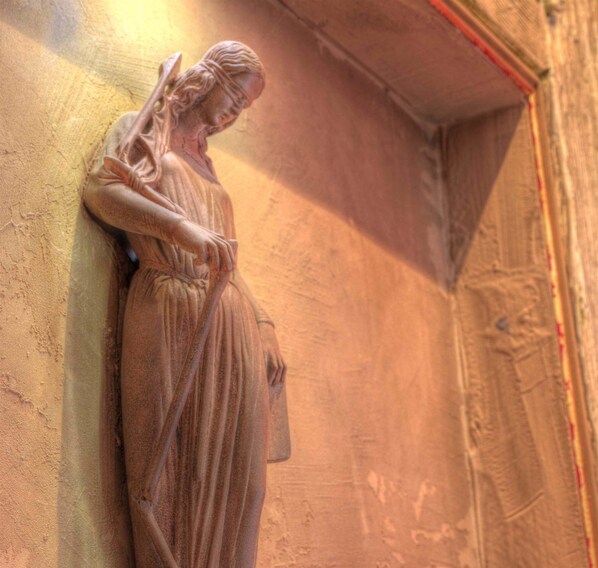 A statue of a woman leaning against a wall.