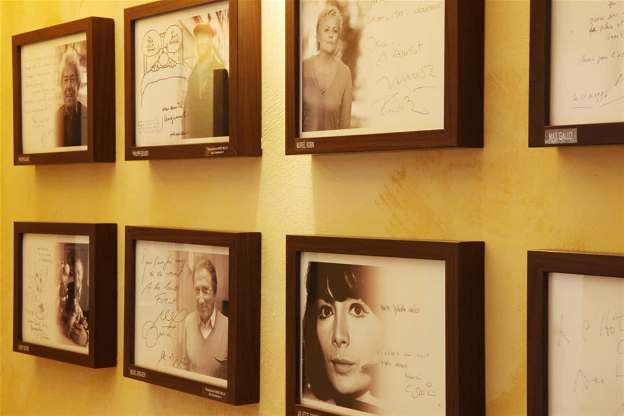 Des photographies encadrées ornent un mur, chacune accompagnée d’une note manuscrite.