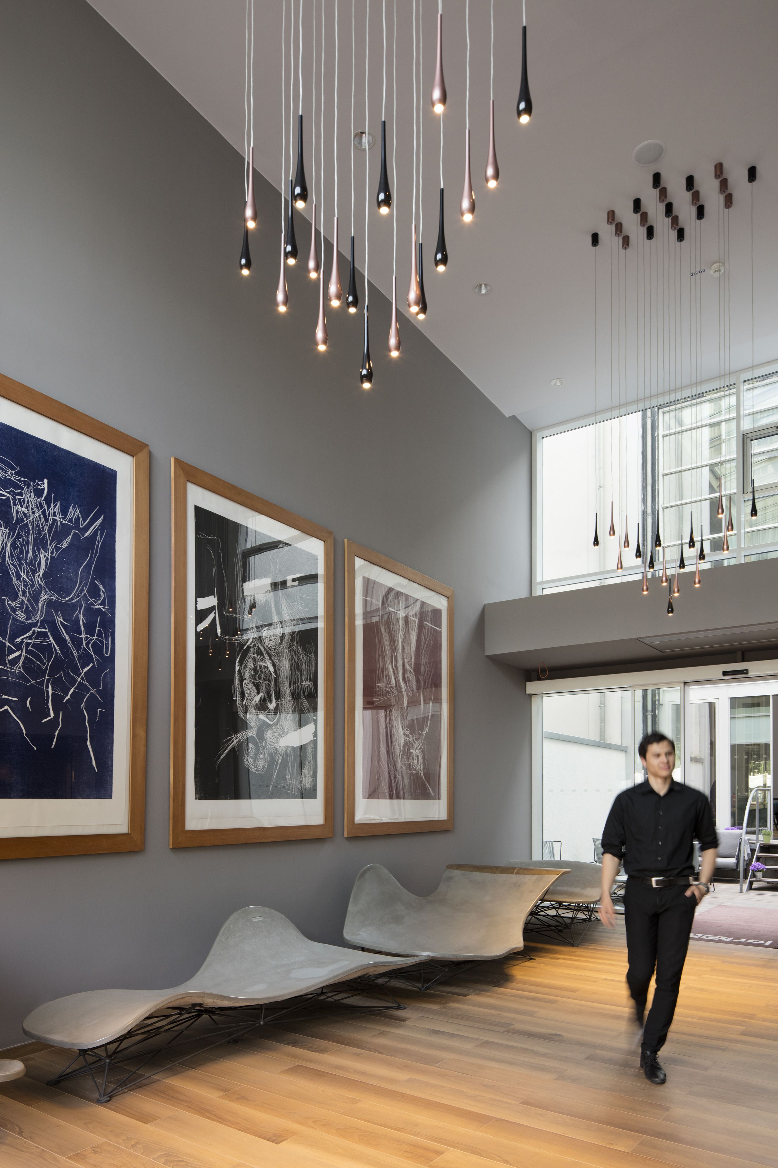 A modern interior with abstract art, a unique seating area, and contemporary lighting.