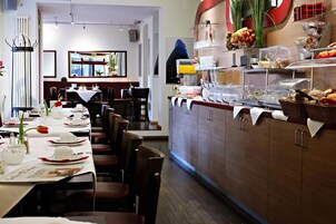 A restaurant with a buffet counter, dining tables, and chairs.