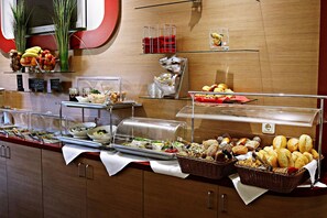 A buffet with various food items and a clear glass display case. - Air in Berlin Hotel (Berlin)