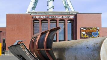 A large industrial structure with a sign reading "DEUTSCHES BERGBAU-MUSEUM" and a large cylindrical object in front.