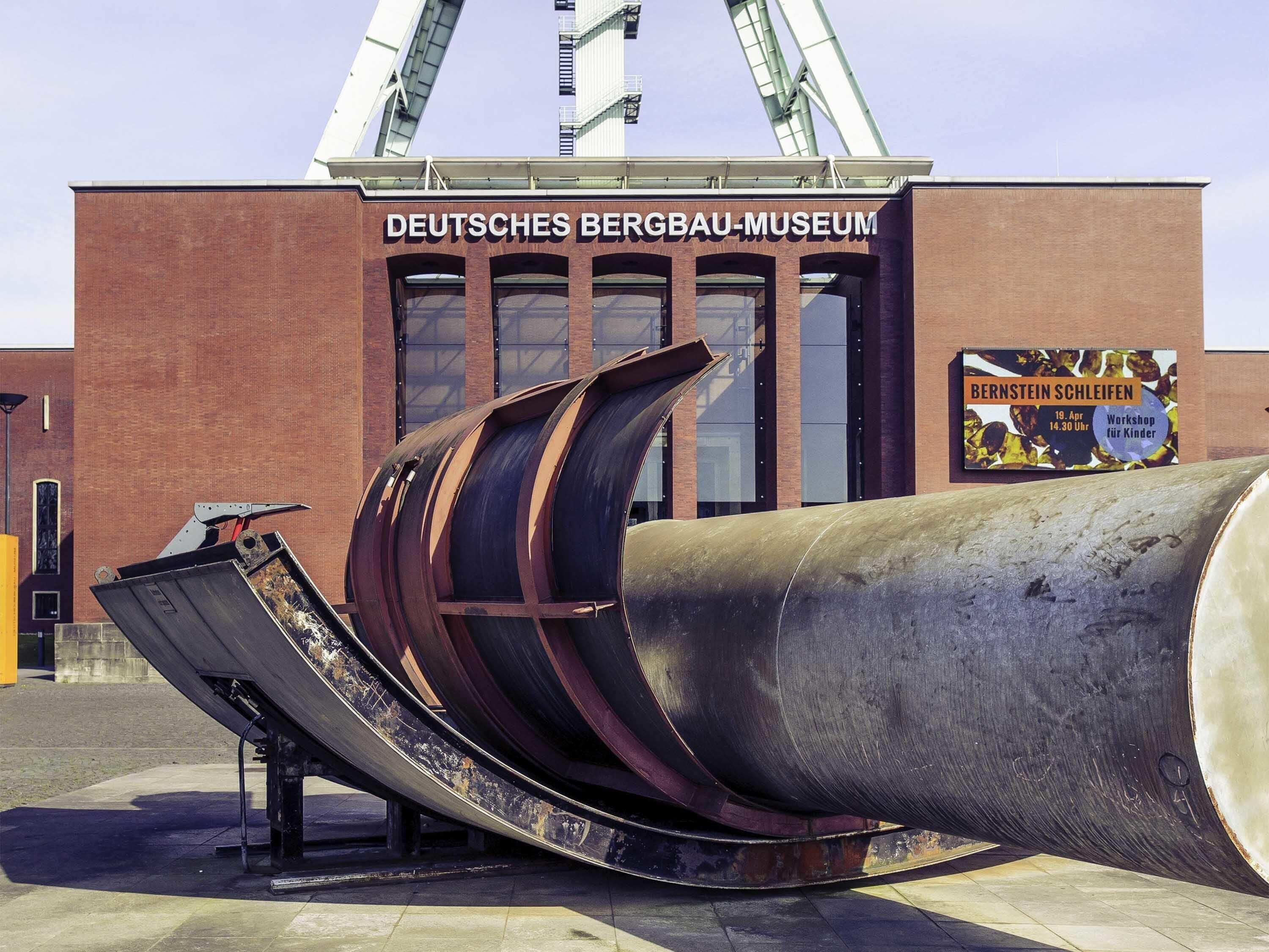 Das Gebäude des Deutschen Bergbau-Museums mit einer großen Metallskulptur davor.