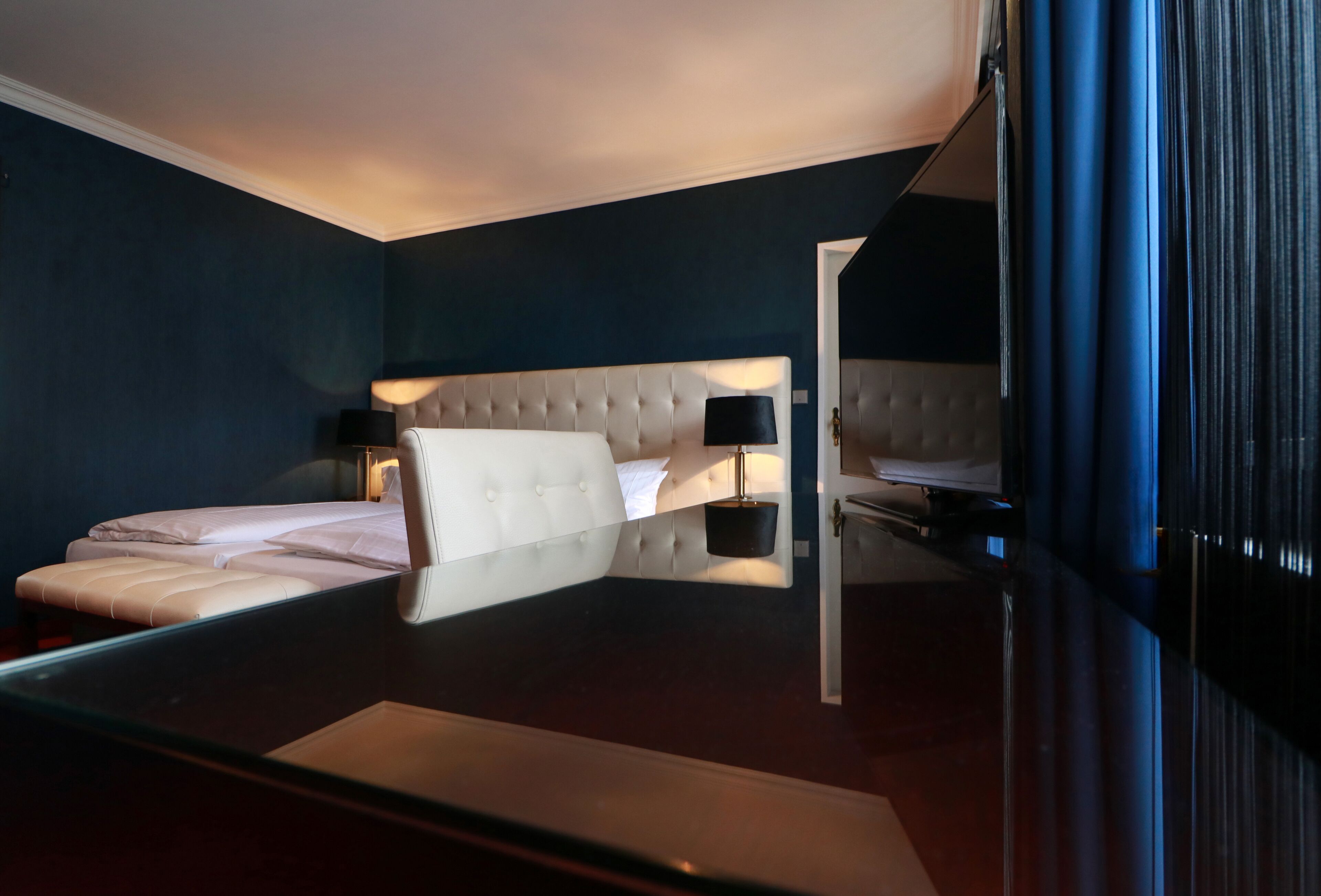 Ein modernes Hotelzimmer mit einem großen Bett, einem Nachttisch und einem Beistelltisch.