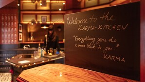 A chalkboard sign in a restaurant with the text "Welcome to the KARMA-KITCHEN 'Everything you do comes back to you.' KARMA". - Hotel Haverkamp (Bremerhaven)