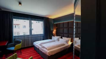 A hotel room with a large bed, a desk, and a chair.