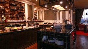 A modern kitchen with a brick wall, black tiled countertops, and various kitchen appliances. - Hotel Haverkamp (Bremerhaven)