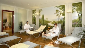 Un cuarto de spa con dos sillones reclinables, un mural de un paisaje y una puerta que da a otra habitación.