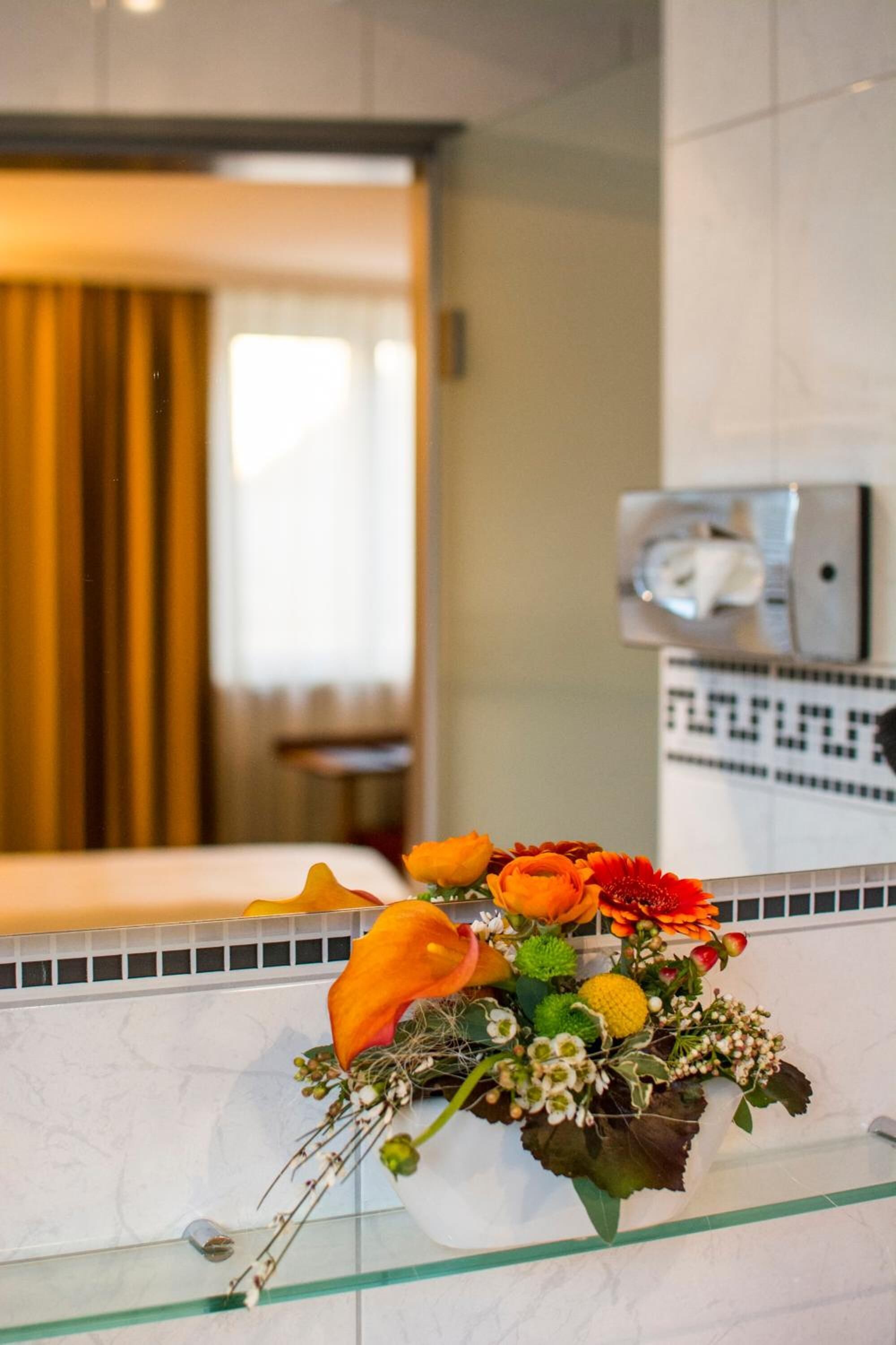 Une salle de bain avec une paroi en verre, un lavabo et un miroir.
