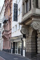 Un hotel con fachada clásica, ventanas amplias y un llamativo letrero que dice 'HOTEL'.