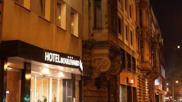 Ein Hotel mit einem gut sichtbaren 'HOTEL'-Schild, einem Glastür-Eingang und klassischer Architektur.
