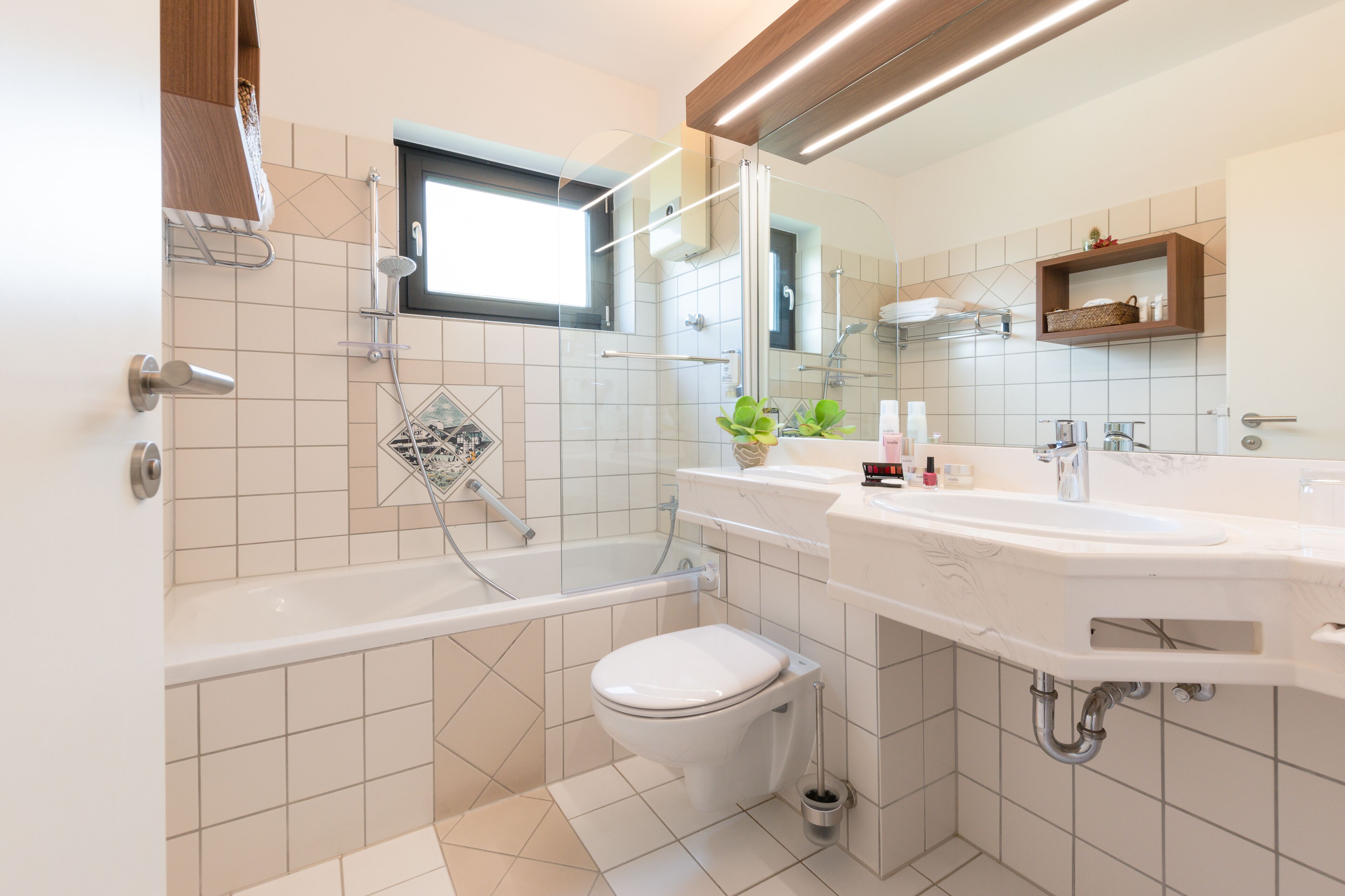Un baño moderno con bañera, inodoro y dos lavamanos.