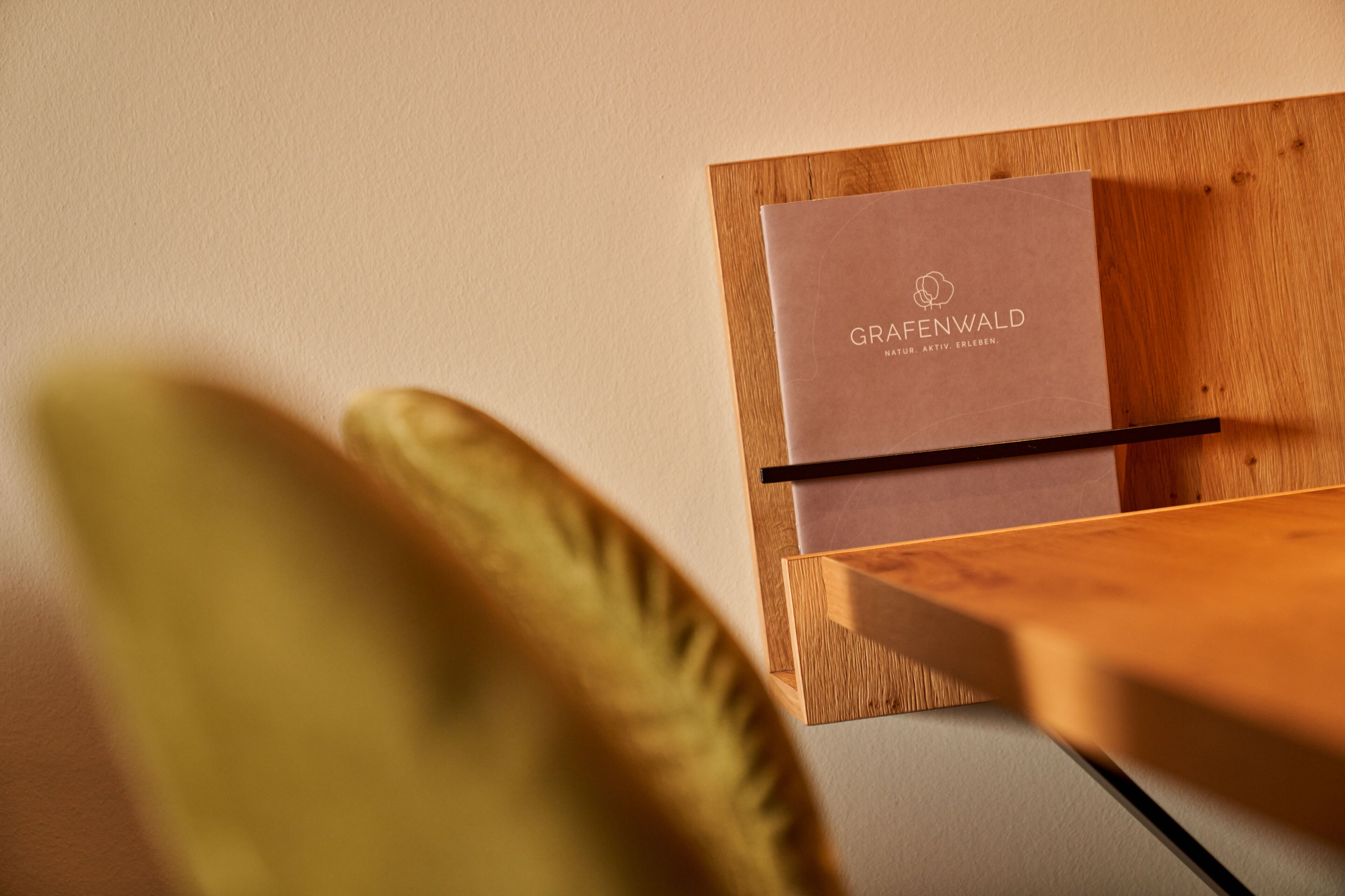 A wooden desk with a box labeled "GRAFENWALD" and a pen on it.