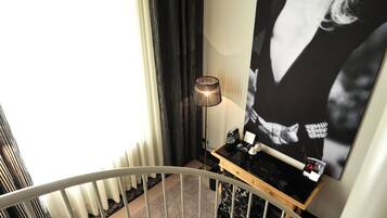 Eine Treppe mit beigem Teppich, einem weißen Geländer und einem schwarz-weißen Poster an der Wand.