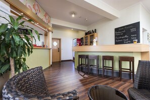 Enjoy a meal at the central counter, surrounded by wicker chairs and a lush potted plant.