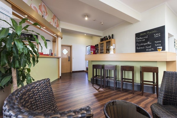 A restaurant with wicker chairs, a bar area, and a chalkboard menu. - Good Morning Erfurt (Erfurt)