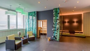 Ein moderner Wellnessbereich mit Sitzgelegenheiten, einer Sauna und einer Rezeption.