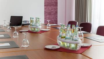 A conference table with a beverage cooler, glasses, and documents.