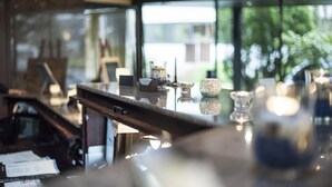 Una cocina moderna con encimera de mármol, cafetera y vistas al exterior.