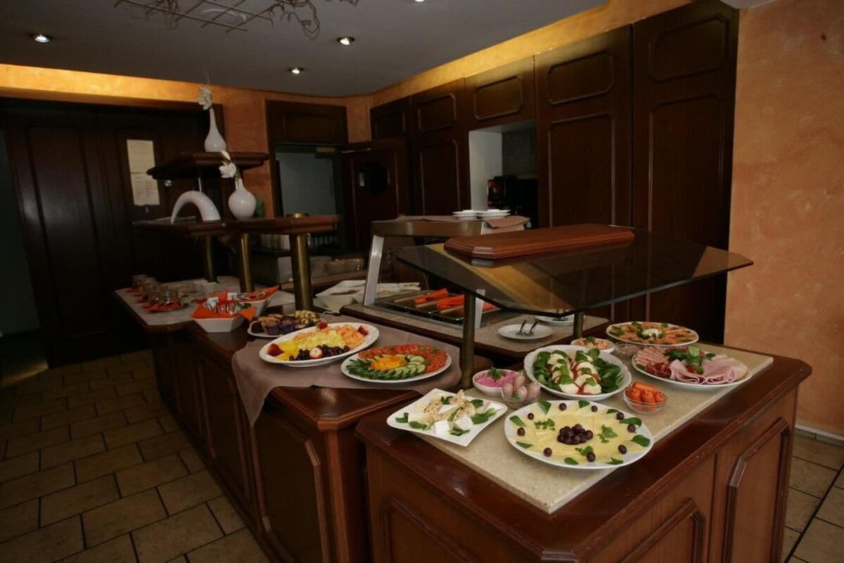 A buffet setup with various food items and a bar area.