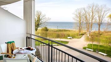 Een balkon met uitzicht op een strand en de zee.