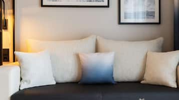 A modern living room with a sofa, a side table, and two framed pictures on the wall.