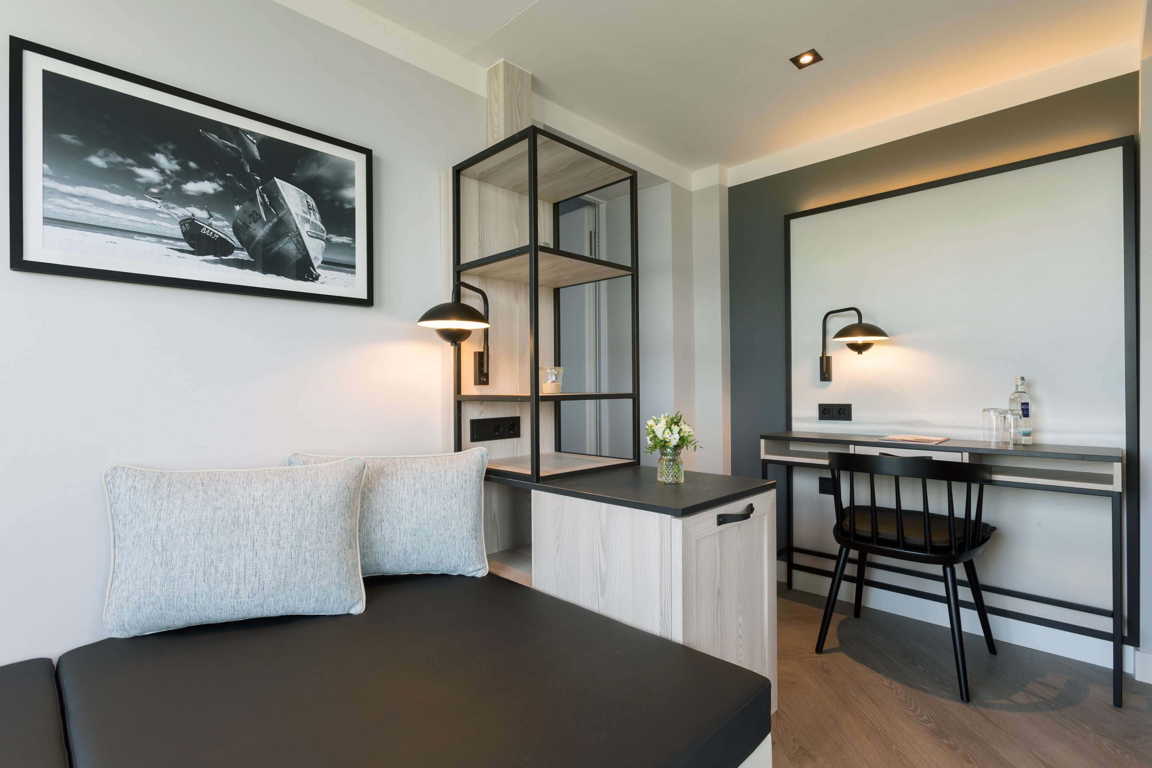 A modern bedroom with a bed, a desk, and a chair.