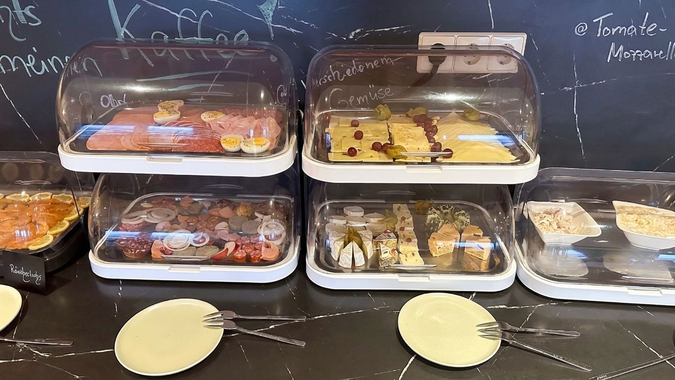 A buffet with various food items displayed in clear containers.