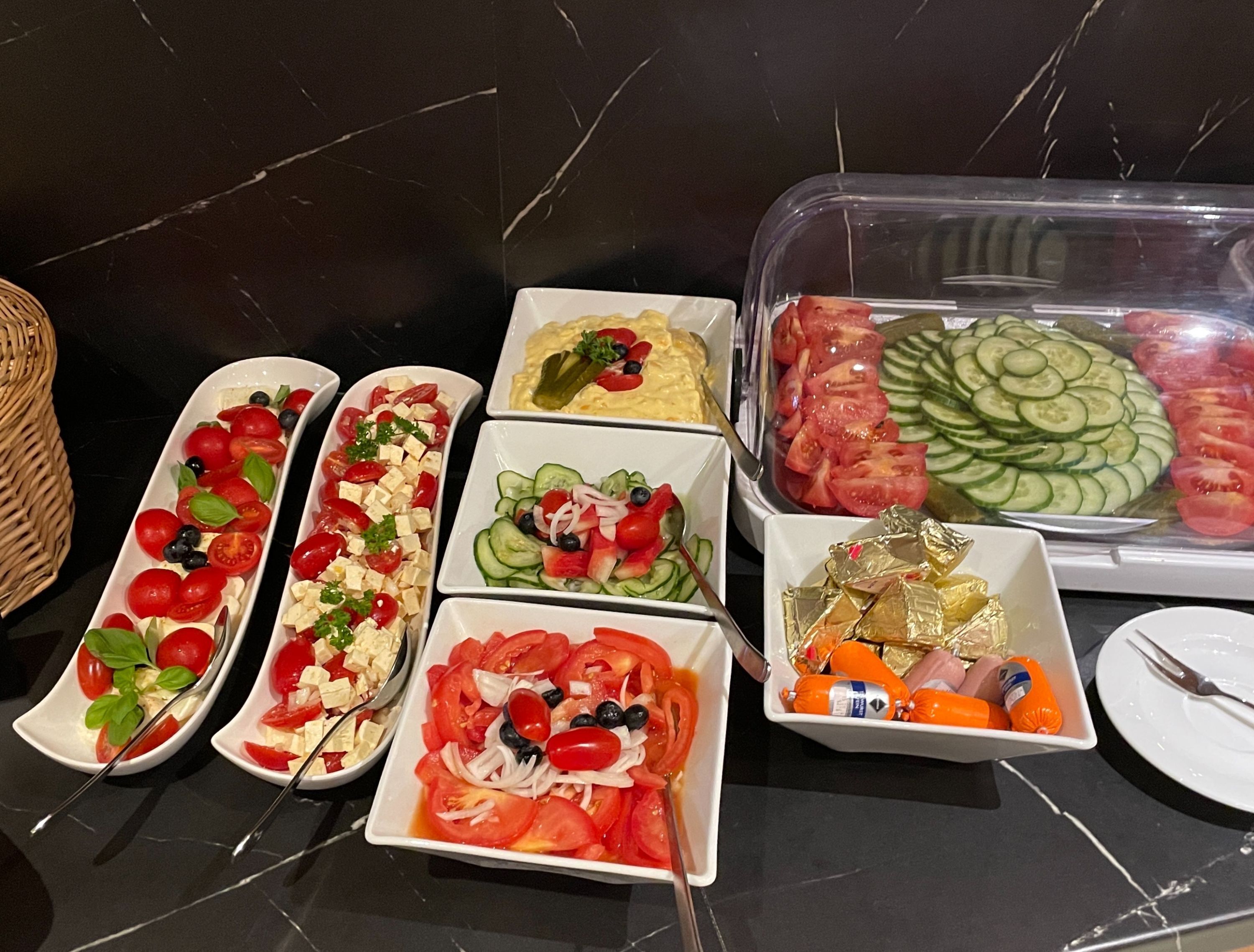 Variedad de alimentos dispuestos sobre una mesa, entre ellos ensaladas, frutas y productos envasados.