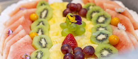 A fruit platter with various fruits including watermelon, kiwi, grapes, and strawberries.