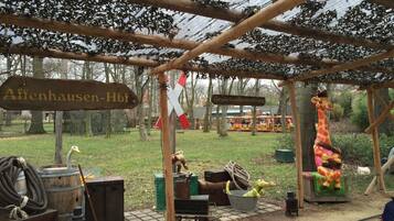 Entorno rústico al aire libre con una estructura de madera, un letrero que dice 'Affenhausen-Hbf.' y un pequeño modelo de tren.
