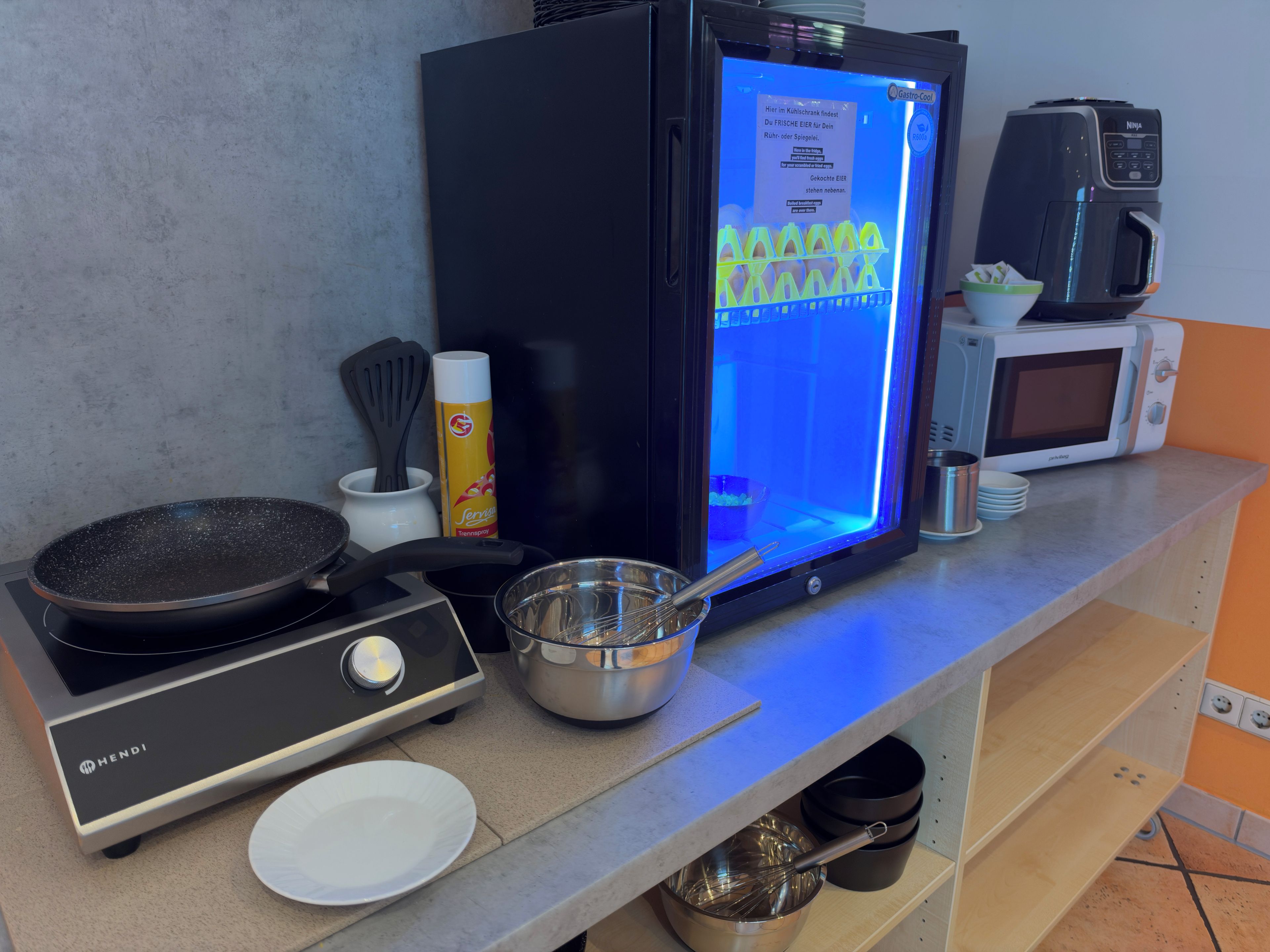 Una cucina con fornello, forno a microonde e macchina da caffè.
