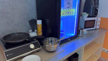 Una cucina con fornello, forno a microonde e macchina da caffè.