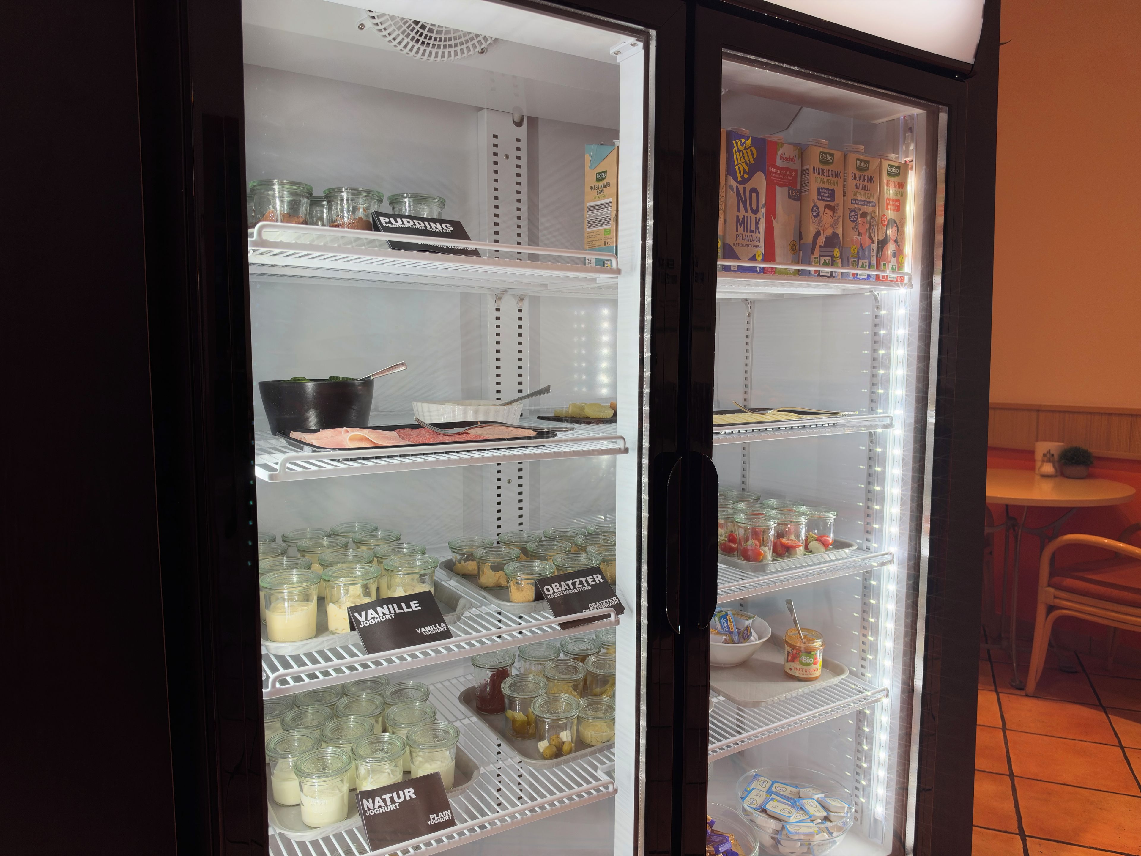 A refrigerated display case with various dairy products and condiments.