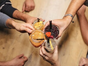 Un grupo de personas sosteniendo bebidas con pajitas; una de las bebidas lleva una fresa como decoración.