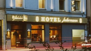 A hotel with a sign reading "HOTEL Jedermann." It features multiple windows and a balcony. - Hotel Jedermann (Munich)