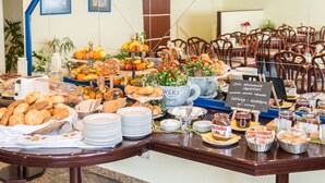 Ein Buffet mit verschiedenen Speisen und einem auf Deutsch beschrifteten Schild.