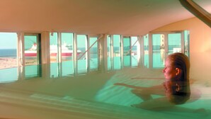 Una habitación amplia con ventanas grandes y vista al mar.