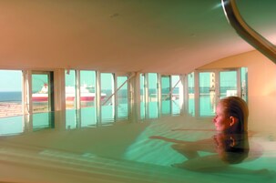 Una piscina techada, sillones reclinables de piscina