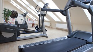 A gym with a treadmill, elliptical, and stationary bike. - Vienna House by Wyndham Baltic Stralsund (Stralsund)