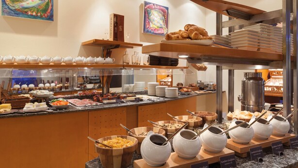 A buffet with various food items, serving utensils, and a coffee station. - Vienna House by Wyndham Baltic Stralsund (Stralsund)