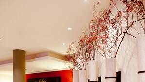 A modern lobby with a large television, seating area, and decorative wall elements. - Vienna House by Wyndham Baltic Stralsund (Stralsund)