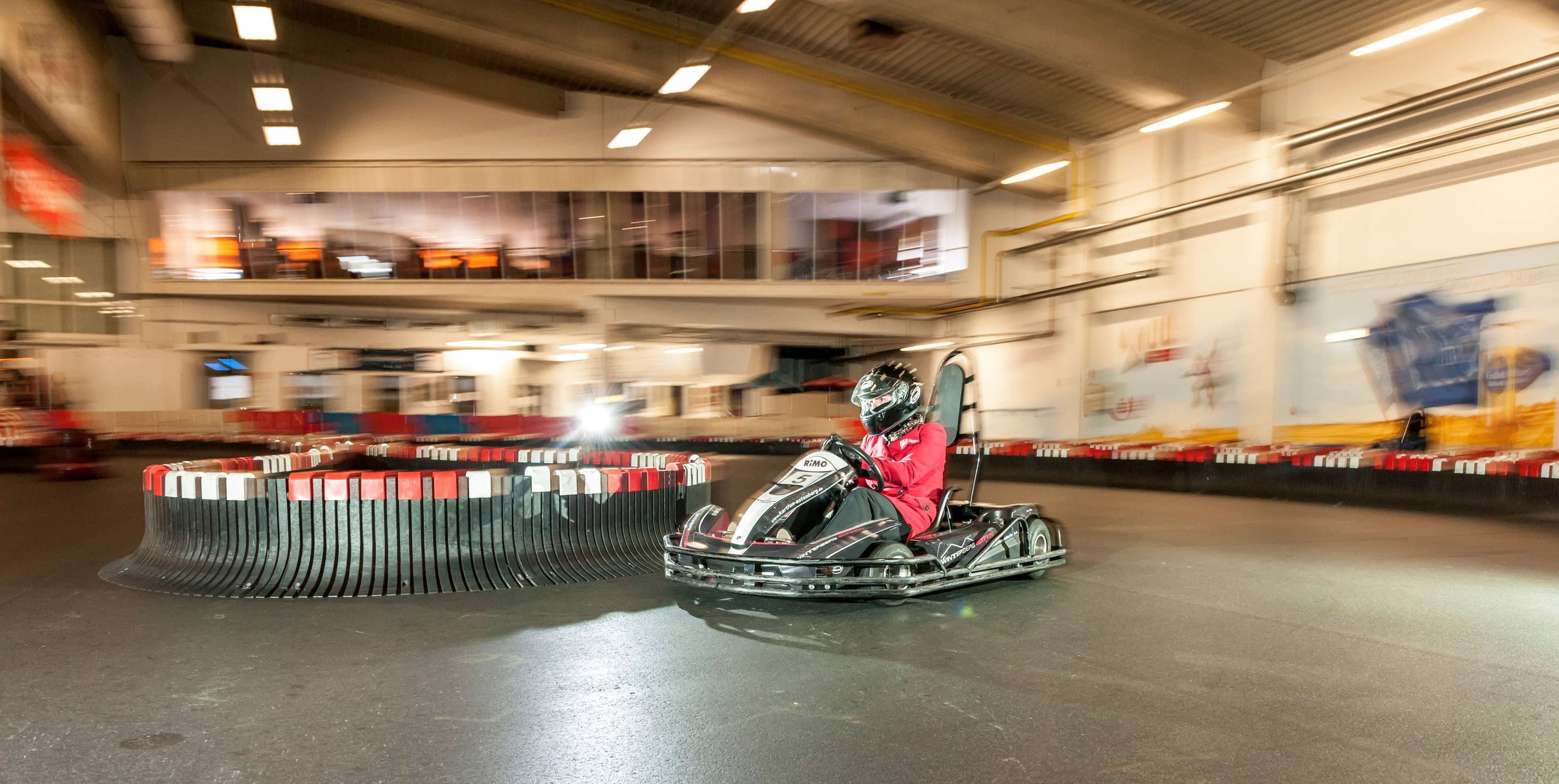 Una pista de karts con un kart y su piloto en el centro.