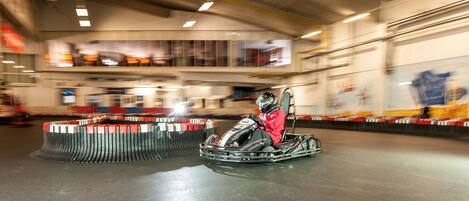 Una pista de karts con un kart y su piloto en el centro.